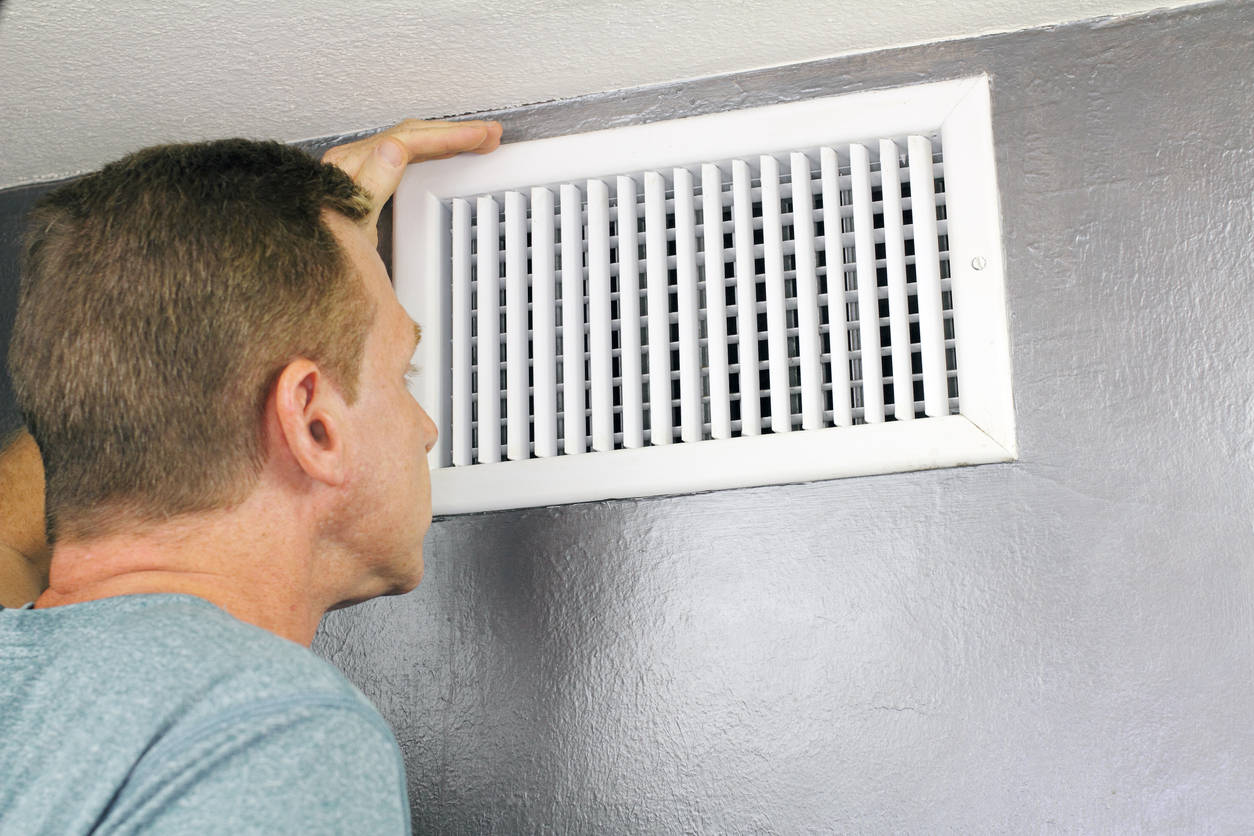 Tech Inspecting AC Vent